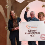 Kreidekreis-Team unter Weihnachtsbaum mit Glückskugeln